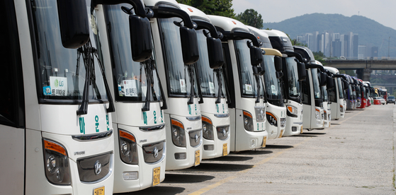 Chartered buses are lined up at a parking lot in Songpa District, southern Seoul, on Wednesday. A revision on the operating year limit of chartered buses from the current 11 years to 13 years amid the Covid-19 pandemic was recently proposed. [NEWS1]