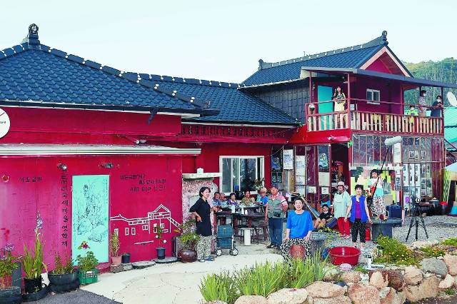 지난달 말 강원도 인제군 서화면 서화2리 신지승 영화감독의 집에서 '끄트머리 마을영화제'가 열리는 날 주민들이 모였다. 시원한 냉콩국수와 수박을 먹고 난 뒤라 꼭 마을 잔칫날 같다. 박성열 할아버지, 박부녀 김원용 손도하 할머니, 김 할머니 사위 이성형씨(왼쪽부터)가 나무의자 뒤에 앉았고 마술도 하는 전대원씨와 칼국수를 준비한 이금란·마명옥씨가 앞에 섰다. 신 감독(맨 앞줄 파란 상의)과 아내 이은경 PD(맨 앞줄 왼쪽 검은 상의) 부부, 붐 마이크를 든 하륵, 2층 테라스에서 슬레이트를 든 하늬, 해먹에 앉은 동네 아이와 구경 온 테라스 민박객 등이 함께하면서 한 편의 영화 장면 같은 풍광이 연출됐다.