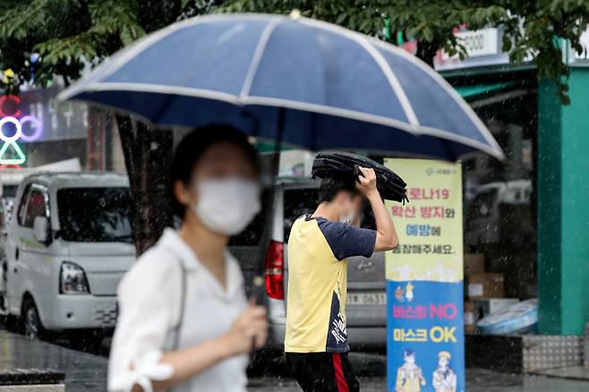 제9호 태풍 ‘루핏’이 오늘 밤부터 최근접할 것으로 예보된 8일 오후 서울 서대문구 신촌거리에서 시민들이 비를 피하고 있다. 뉴시스