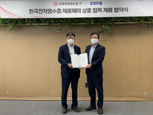 이근주 한국간편결제진흥원장(오른쪽)과 이동호 한국전자영수증 대표가 전자영수증 서비스 제고를 위한 업무협약을 체결하고 기념촬영을 하고 있다.(사진=한국간편결제진흥원 제공)