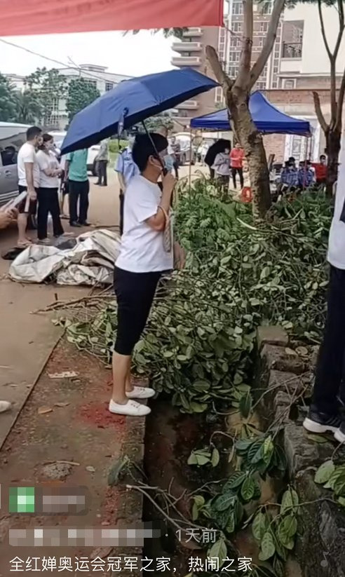 취안훙찬(14)의 집 앞에 몰려든 구경꾼들이 폭우가 쏟아지자 우산을 쓰고 구경하고 있다. [신화망 캡처]