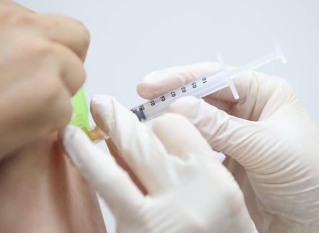 A health worker administers a COVID-19 vaccine at a local hospital in Seoul. (Yonhap)