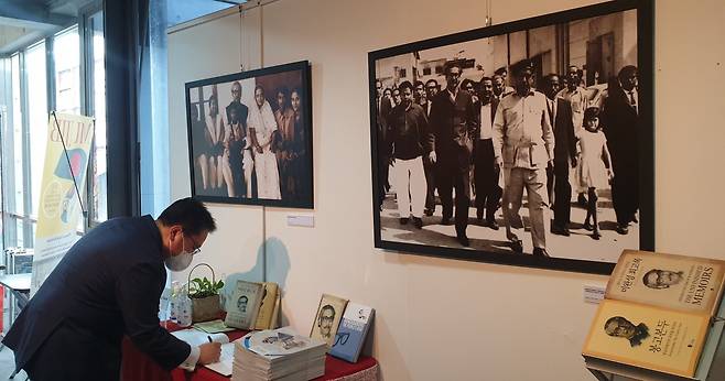 A visitor signs the guest book at a photo exhibition celebrating the life and legacy of Bangladesh’s national hero, Sheikh Mujibur Rahman, known as Bangabandhu, last week at a cultural center in Seoul. (Embassy of Bangladesh in Seoul)