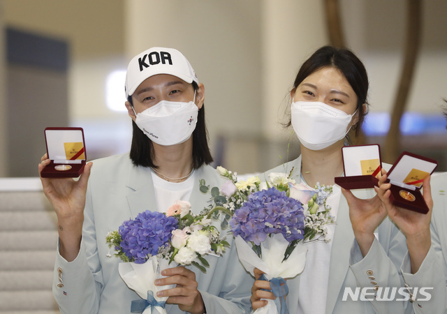 [인천공항=뉴시스] 고승민 기자 = 대한민국 여자배구 김연경, 양효진이 9일 인천국제공항 2터미널을 통해 귀국, 배구협회로부터 기념주화를 받은 뒤 기념촬영을 하고 있다. 2021.08.09. kkssmm99@newsis.com