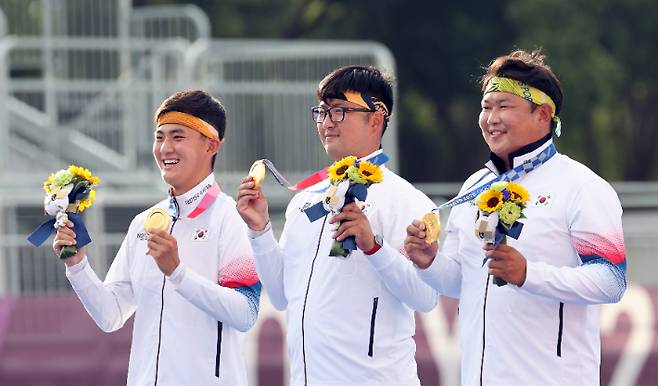 김제덕, 김우진, 오진혁이 지난달 26일 도쿄 유메노시마 양궁장에서 열린 남자 양궁단체전 시상식에서 취재진에게 금메달을 들어보이고 있다. 올림픽사진공동취재단