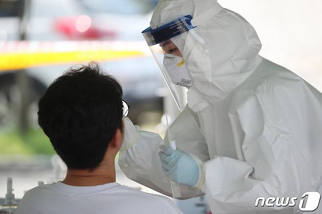 11일 오후 대구 수성구 대구스타디움 제3주차장에 마련된 임시선별검사소에서 의료진이 신종 코로나바이러스 감염증(코로나19) 진단검사를 위해 방문한 시민의 검체를 채취하고 있다. (사진은 기사의 특정 사실과 관련 없음) 2021.8.11 /뉴스1 © News1 공정식 기자