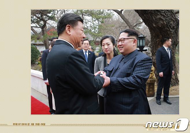 북한 외국문출판사가 공개한 김정은 국무위원장 화보 '대외관계 발전의 새 시대를 펼치시어'. 김 위원장이 2018년 3월 중국을 방문해 시진핑 주석과 양원재에서 열린 오찬에 참석하며 악수하는 모습이 실려있다.(외국문출판사 화보 캡처) 2021.5.12/뉴스1