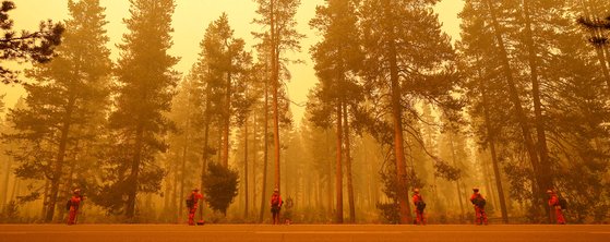 지난 8일 미국 캘리포니아주 웨스트우드타운 인근에서 발생한 산불. 캘리포니아주 소방대원들이 산불 앞에서 산불 확산 방지 대책을 수립하고 있다. [로이터=연합뉴스]