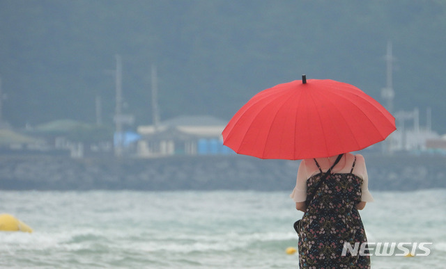 [제주=뉴시스]우장호 기자 = 전국적으로 장맛비가 내리는 4일 오후 제주시 한림읍 금릉해수욕장을 찾은 관광객이 우산을 쓴 채 바다를 응시하고 있다. 2021.07.04. woo1223@newsis.com