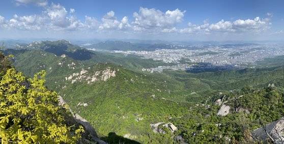 북한산 인수봉에서 바라본 하루재. 맨앞 능선 중 가장 깊게 팬 곳, 즉 바위 투성이인 영봉 바로 오른쪽 안부가 하루재다. 김홍준 기자