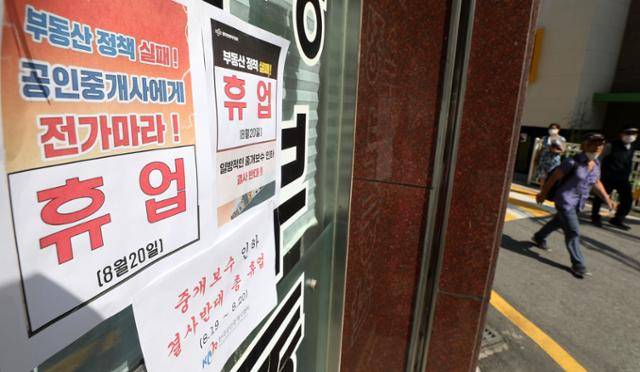 정부가 부동산 중개보수 개편안을 최종 확정한 20일 서울 시내 한 공인중개사사무소에 중개보수 인하 결사 반대 휴업 안내문이 부착돼 있다. 뉴시스