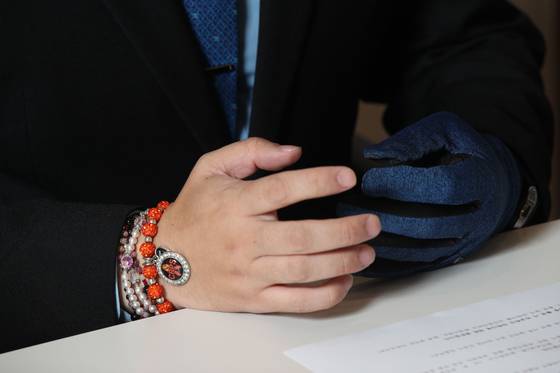 김경태씨는 오른팔에 팔찌를 여러개 끼고 있었다. 가장 눈에 띄는 주황색 팔찌는 CRPS에 대한 인식 개선을 위한 상징 팔찌라고 한다. 김씨의 왼손은 사계절 내내 장갑으로 감싸져 있다. 우상조 기자