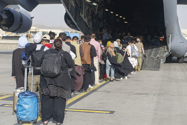 Evacuees board a US military aircraft in Kabul, Afghanistan. (UPI/Yonhap News)