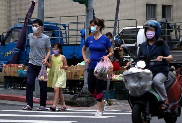 대만 수도 타이베이에서 13일 마스크를 착용한 시민들이 노점상에서 구입한 채소 등을 들고 횡단보도를 건너고 있다. 타이베이=AP 뉴시스