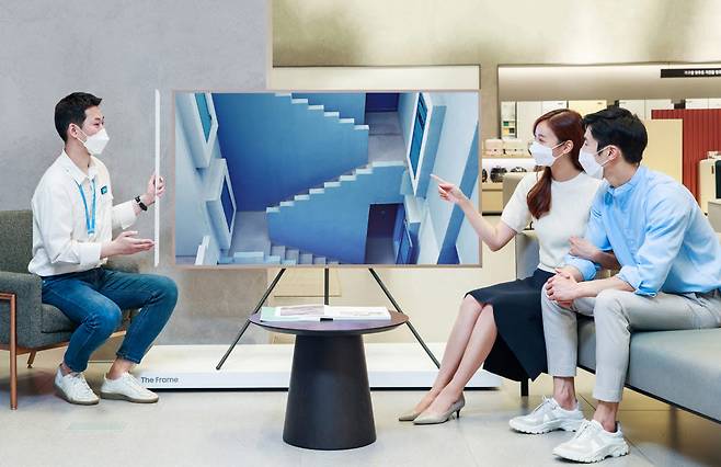 삼성 디지털프라자 대치본점에서 삼성전자 판매 직원이 혼수가전을 마련하려는 고객에게 더 프레임을 소개하고 있다.