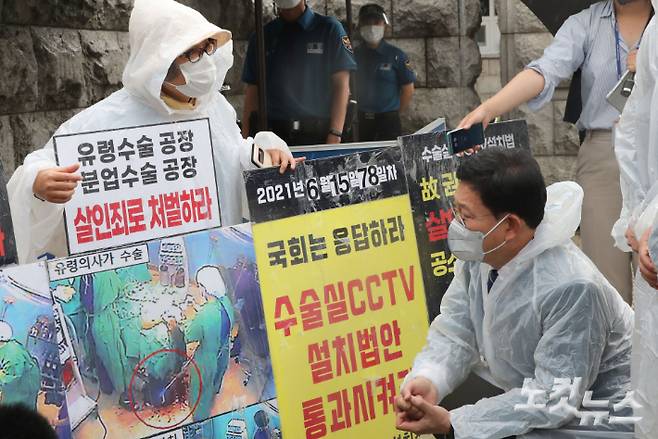 더불어민주당 송영길 대표가 지난 6월 국회 정문 앞에서 수술실 CCTV 설치 1인 시위를 하고 있는 의료사고 피해자 고 권대희씨 유가족인 이나금 의료정의실천연대 대표를 만나 대화하는 모습. 윤창원 기자