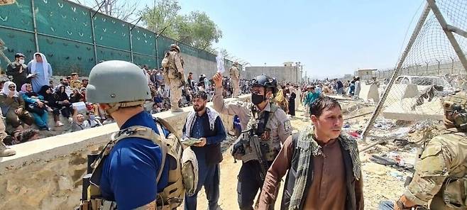 Ally soldiers look for Afghans to airlift to South Korea with a sign that reads “Korea” on one soldier’s hand at the Kabul international airport. (provided by the Ministry of Foreign Affairs)