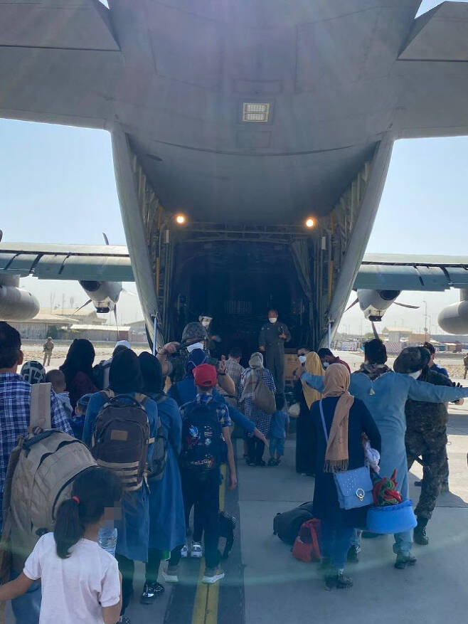 한국 정부와 협력한 아프가니스탄인들이 24일 국내 이송을 위해 카불 공항에 도착한 한국 공군 수송기에 오르고 있다.(사진=외교부 제공)