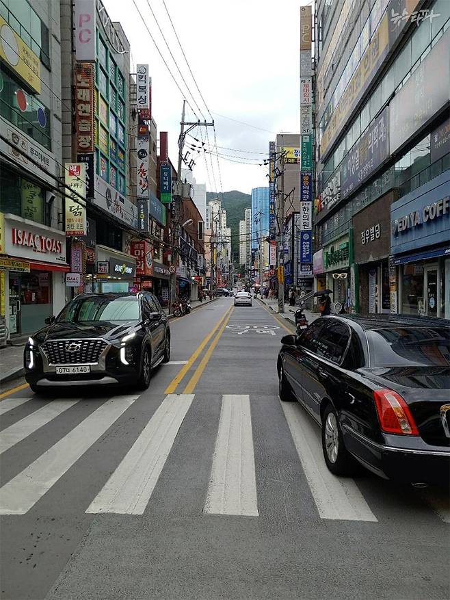 태양광을 반사하는 차열 페인트를 덧칠한 도로에 자동차가 주차돼 있다.&nbsp;