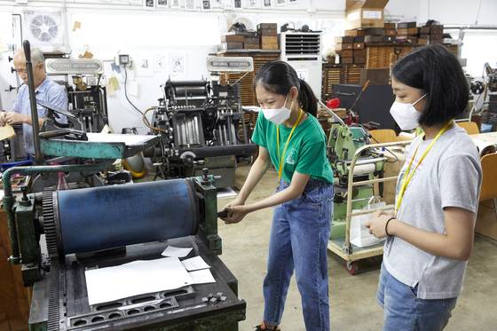 활판 위에 원하는 형태의 종이를 올린 뒤 손잡이를 천천히 돌려 종이에 잉크를 찍어내면 수동 활판 인쇄 작업 끝.