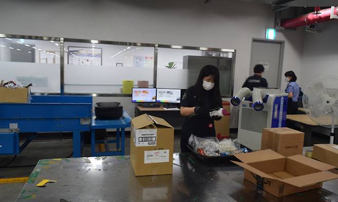 인천세관 특송통관1과 이은비 관세행정관이 마약 등 반입금지 물품이 담긴 것으로 추정되는 상자를 열어 내용물을 살펴보고 있다.