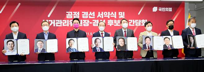 국민의힘 대선 주자들이 5일 서울 여의도 국민의힘 중앙당사에서 열린 공정경선 서약식에서 자신의 사진이 담긴 서약서를 보이며 기념촬영을 하고 있다. 왼쪽부터 황교안, 최재형, 장성민, 장기표, 윤석열, 원희룡, 박찬주, 박진 후보. 홍준표, 유승민, 하태경, 안상수 후보는 ‘역선택 방지조항 제외’를 주장하며 불참했다. 허정호 선임기자