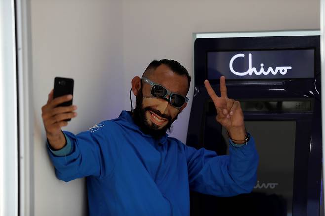 중미 엘살바도르에서 한 시민이 7일(현지시간) 비트코인을 미 달러화로 바꿀 수 있는 키오스크 앞에서 기념 사진을 찍고 있다. 엘살바도르는 이날 비트코인을 법정통화로 세계에서 처음 인정·통용하기 시작했다. [EPA]