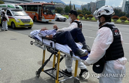 9일 오전 경남 창원시 창원시청 앞에서 휘발유를 끼얹고 분신을 시도한 버스기사 A 씨가 구급차로 실려 가고 있다. 다행히 주변 사람들이 A 씨를 제지해 불상사는 일어나지 않았다. [사진 출처 = 연합뉴스]