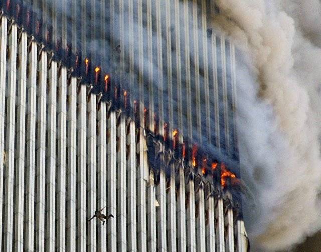 건물에서 연기와 불이 뿜어져 나오는 동안 한 사람이 뉴욕 세계 무역 센터의 북쪽 타워에서 떨어지고 있다. AP=뉴시스