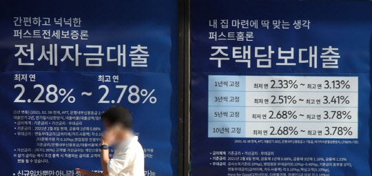 한 시민이 주택담보대출 안내문이 걸린 시중은행 앞에서 통화하고 있다. <연합뉴스>