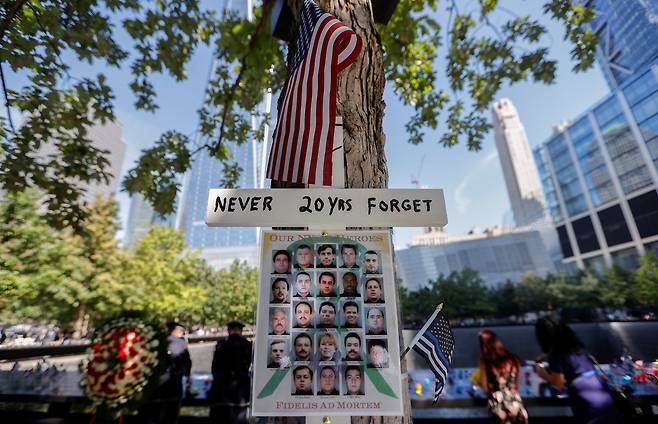 뉴욕 맨해튼 9·11추모박물관에 '20년 동안 절대 잊지 않았다'라고 쓴 피켓이 희생자 사진과 걸려있다./로이터 연합뉴스