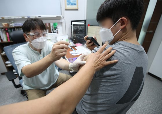 지난 6월 10일 서울 동작구의 한 의원에서 얀센 백신을 접종받는 시민이 휴대전화로 인증샷을 찍고 있다. 연합뉴스