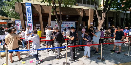 12일 오전 서울 송파구 송파보건소 선별진료소에서 시민들이 검사를 받기 위해 줄을 서있다. 연합뉴스