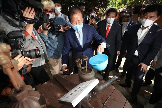 박정희 생가 찾아 국민의힘 대선 주자인 홍준표 의원이 12일 경북 구미 상모동 박정희 전 대통령 생가를 찾아 박 전 대통령이 직접 사용했던 우물의 수동 펌프에 마중물을 넣고 있다.  연합뉴스
