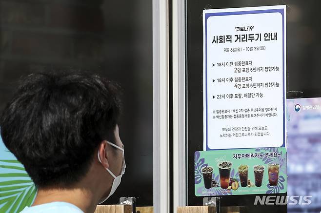 [서울=뉴시스] 정병혁 기자 = 10월 3일까지 추석 연휴 특별 방역 대책이 포함된 사회적 거리두기가 시행되고 있는 12일 오전 서울시내 한 커피전문점에 거리두기 관련 안내문이 붙어 있다.  2021.09.12. jhope@newsis.com
