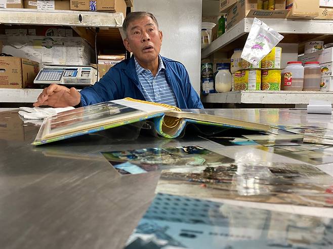 11일(현지시간) 미국 뉴욕 맨해튼에 있는 자신의 식료품점에서 20년전 앨범을 보여주는 윤건수씨. 뉴욕 이경주 기자 kdlrudwn@seoul.co.kr