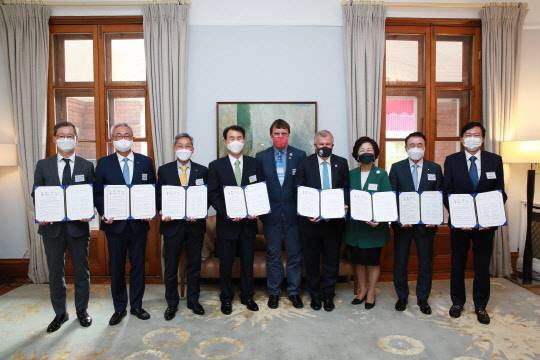 13일 서울 중구 정동 주한영국대사관에서 열린 국제 기후리스크 관리모형 개발(프론티어 1.5D)을 위한 업무협약식에서 최은석(왼쪽부터) CJ제일제당 사장, 김준 SK이노베이션 총괄사장, 윤종규 KB금융지주 회장, 정은보 금융감독원 원장, 나이젤 토핑 COP26 UN 고위급기후변화대사, 사이먼 스미스 주한 영국대사 등이 기념사진을 찍고 있다. <SK이노베이션 제공>