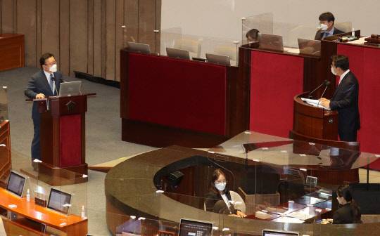 김부겸(왼쪽) 국무총리가 13일 오후 국회 본회의에서 열린 정치 분야 대정부 질문에 출석, 권성동(오른쪽 단상) 국민의힘 의원의 '윤석열 전 검찰총장 고발 사주 의혹' 관련 박지원 국가정보원장 개입설등 질의에 답변하고 있다.국회사진기자단·연합뉴스