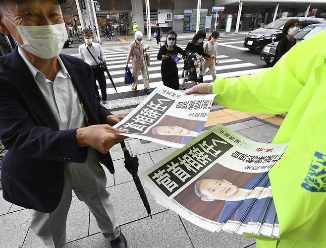 지난 3일 오후 일본 히로시마(廣島)에서 스가 요시히데(菅義偉) 일본 총리가 집권 자민당 총재 선거에 출마하지 않겠다는 소식이 담긴 호외가 배포되고 있다. 신문에는 스가 총리가 사임할 것이라는 취지의 제목이 담겼다. 연합뉴스