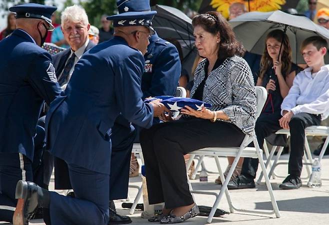 찰스 브라운 미국 공군참모총장(왼쪽 3번째)이 ‘두리틀 특공대’의 마지막 생존자였던 리처드 콜 중령(2019년 타계)의 명예 대령 진급을 기념하는 의식이 끝난 뒤 무릎을 꿇은 채 고인의 딸 신디 콜 챌에게 성조기를 전달하고 있다. 미 공군 홈페이지