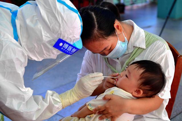 13일 중국 남동부 푸젠성 푸톈시에서 한 어린이가 코로나19 검사를 받고 있다. 푸젠성은 10일부터 나흘간 코로나19 양성 환자 135명이 발생하는 등 확산 추세를 보이고 있다. 푸톈=AFP 연합뉴스
