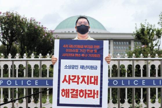 버팀목 플러스 반기매출비교 제외 사업자 비상대책위 김정우 위원장이 서울 여의도 국회 앞에서 4차 재난지원금 소상공인 버팀목 플러스 자금 지급 대상 확대, 이의신청 기간 연장 등을 촉구하는 기자회견을 하고 있다. 연합뉴스