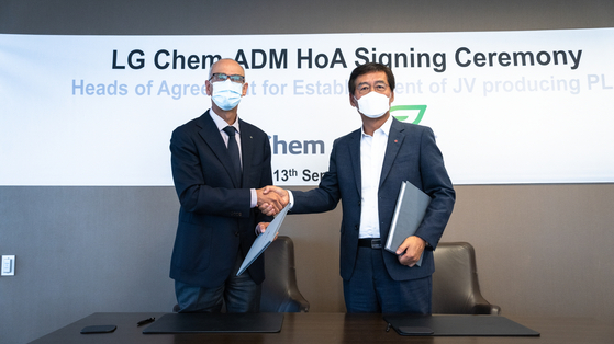LG Chem CEO Shin Hak-cheol, right, shakes hands with Juan Luciano, CEO of Archer Daniels Midland, after signing an agreement at the U.S.-based company's headquarters in Chicago on Monday to build a poly lactic acid plant. [LG CHEM]