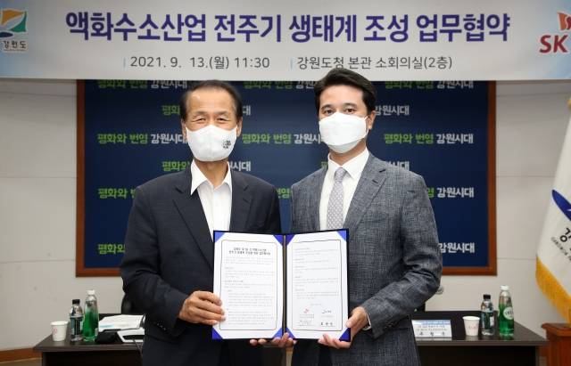 최문순 강원지사(왼쪽)와 추형욱 SK 수소사업추진단장이 13일 강원도청에서 강원도 액화수소산업의 전주기 생태계 조성을 위한 업무협약을 한 뒤 협약서를 들어보이고 있다. 강원도 제공