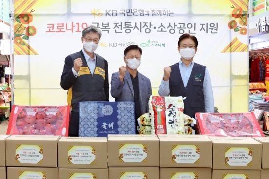 15일 영등포시장에서 열린 코로나19 극복 전통시장·소상공인 지원 행사에서 (왼쪽부터) 허인 KB국민은행장, 김태원 영등포전통시장 상인회장, 유원식 희망친구 기아대책 회장이 기념촬영을 하고 있다.