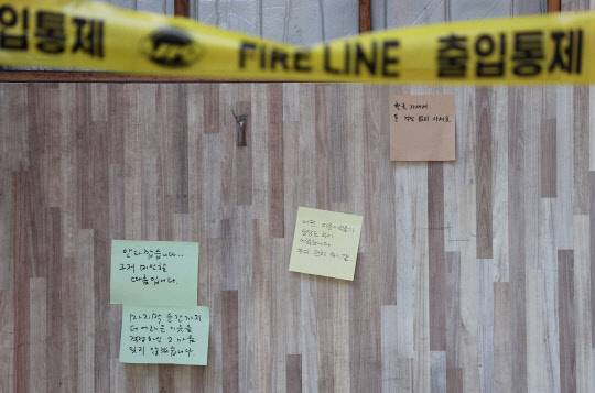 코로나19로 인한 경영난으로 생활고를 겪다 결국 극단적인 선택을 한 자영업자 A(57)씨의 맥줏집 앞에 14일 고인을 추모하는 메모와 국화가 놓여있다. <연합뉴스>