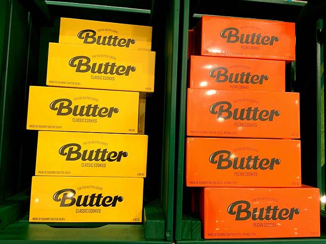 Orange and yellow boxes of cookies named after BTS’ megahit song “Butter” are displayed on a rack. (Park Jun-hee/The Korea Herald)