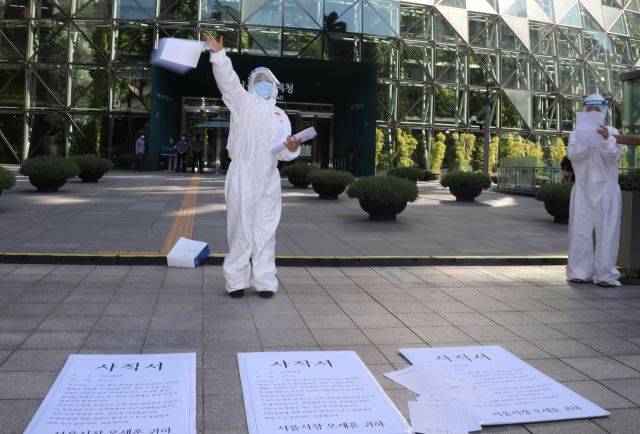 민주노총 의료연대본부가 15일 서울시청 앞에서 코로나19 간호인력 기준 발표 촉구 기자회견 후 사직서를 뿌리는 항의행위를 하고 있다.  지난해 1월부터 올해 7월까지 서울대병원·보라매병원·서울의료원을 떠난 간호사 674명의 사직서이다. 2021.9.15. 연합뉴스