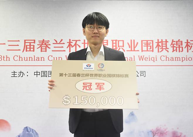 신진서 9단이 우승을 차지한 뒤 상금이 적힌 팻말을 든 채 활짝 웃고 있다.[한국기원 제공]