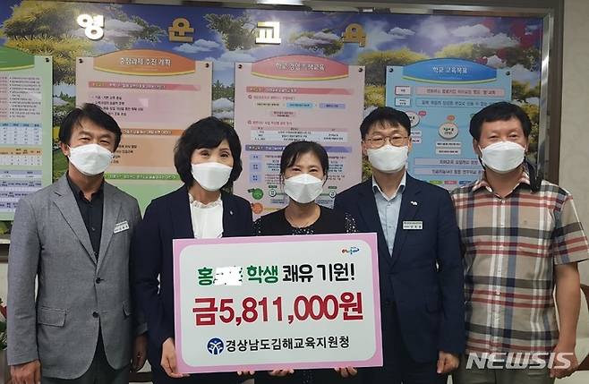 [김해=뉴시스] 홍정명 기자= 경남 김해교육지원청 김현희(왼쪽 두 번째) 교육장이 15일 영운초등학교를 방문해 방화셔터 끼임 사고를 당한 홍모 학생을 위해 모금한 성금을 전달하고 있다.(사진=김해교육지원청 제공) 2021.09.15. photo@newsis.com